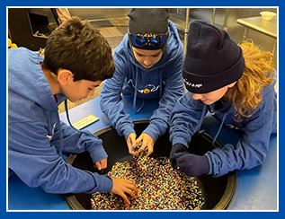 students picking through a bucket of crayons